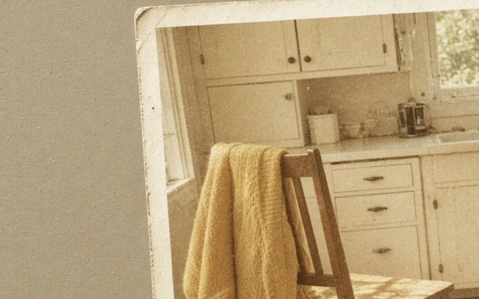 Close crop of a faded kitchen snapshot lying on a table with age damage, the problem this guide is measuring.