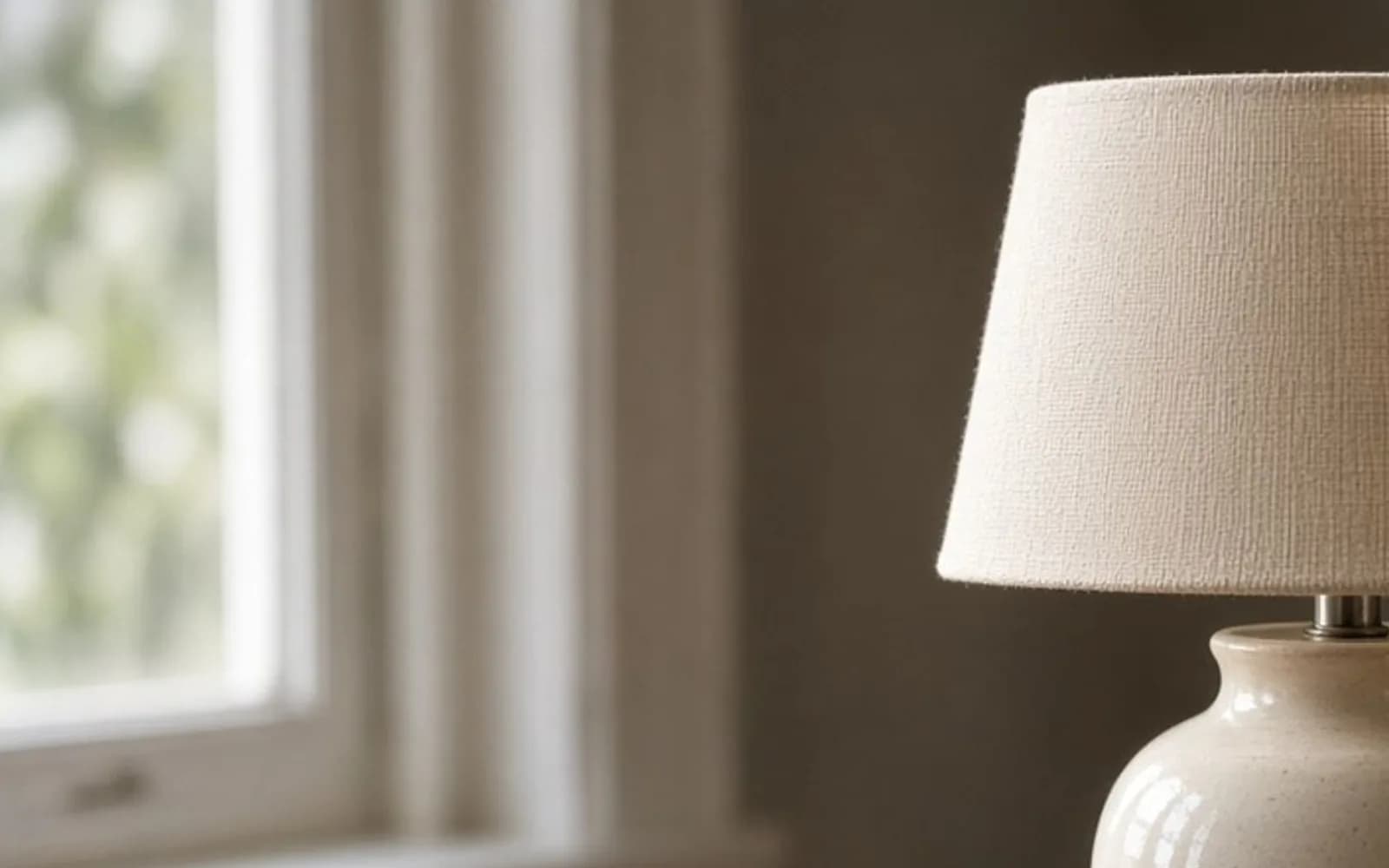 Close crop of a ceramic lamp on an oak desk with pixel damage, the problem this guide is measuring.