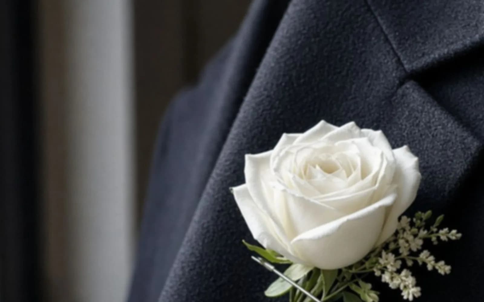 Close crop of a boutonniere on a wool lapel with blur damage, the problem this guide is measuring.