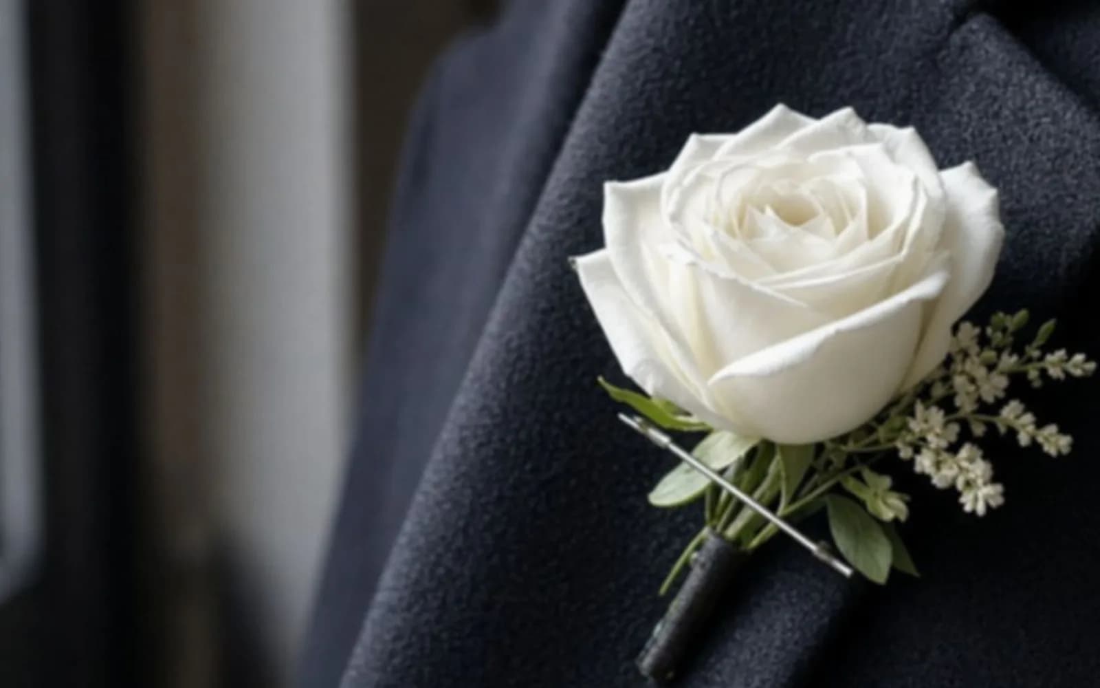 Close crop of a boutonniere on a wool lapel with blur damage, the problem this guide is measuring.